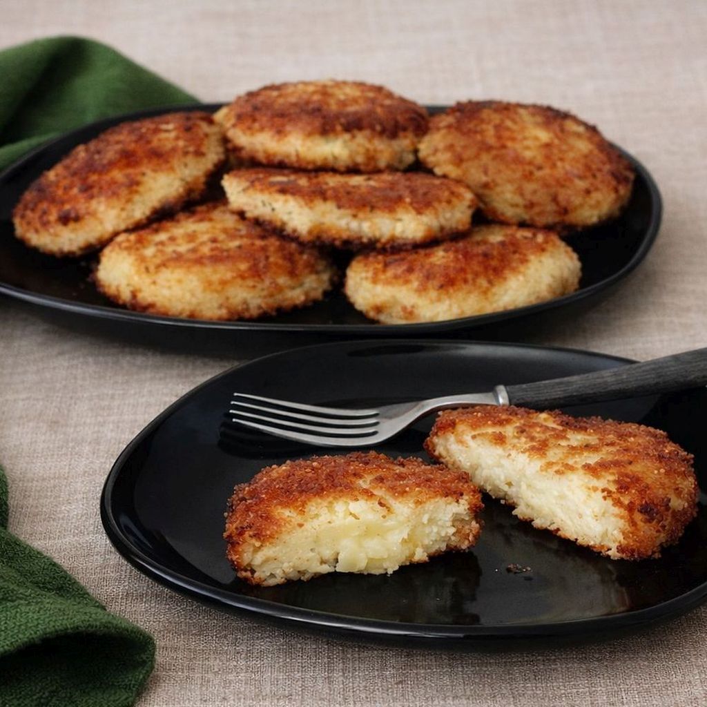 Kotlety ruskie z ziemniaków i twarogu na czarnym talerzu, chrupiące kotlety ruskie, przekrojony kotlet.